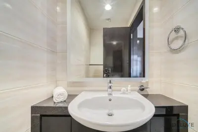 a white bathroom with a sink and a mirror at Urban 1BR at DAMAC Celestia B Dubai South by Deluxe Holiday Homes in Dubai