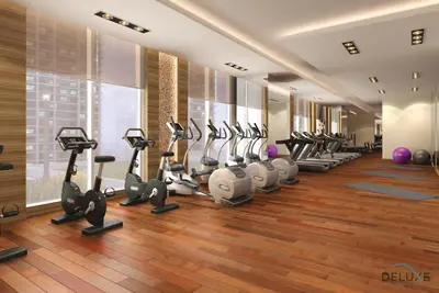 a gym with a row of treadmills and ellipticals at Urban 1BR at DAMAC Celestia B Dubai South by Deluxe Holiday Homes in Dubai