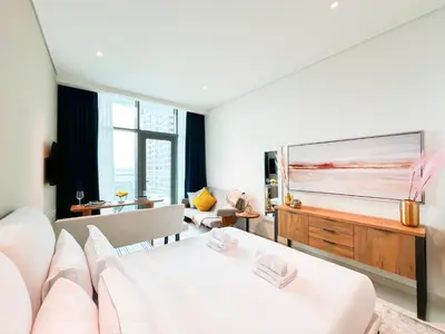 a living room with a white couch and a television at Luxurious Sea-View Studio in Seven Palm - 20AB8 in Dubai