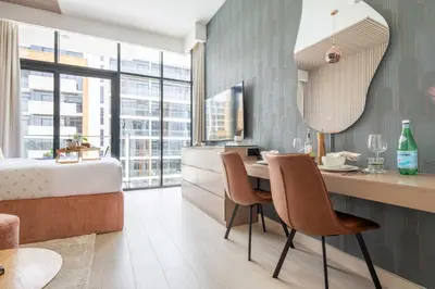 a bedroom with a bed and a desk and chairs at Frank Porter - Riviera 27 in Dubai