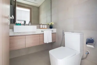a bathroom with a white toilet and a sink at Frank Porter - Riviera 27 in Dubai