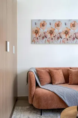 a couch in a living room with a painting on the wall at Frank Porter - Riviera 27 in Dubai