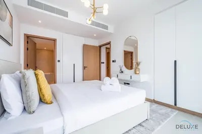 a white bedroom with a large bed and a mirror at Delightful 2BR Apartment in VIDA Residences Dubai Marina by Deluxe Holiday Homes in Dubai