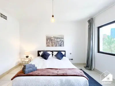 a bedroom with a large bed with blue pillows at Luxury 2Bedroom with Terrace & Burj Khalifa view in Dubai