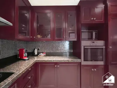 a kitchen with burgundy cabinets and granite counter tops at Luxury 2Bedroom with Terrace & Burj Khalifa view in Dubai