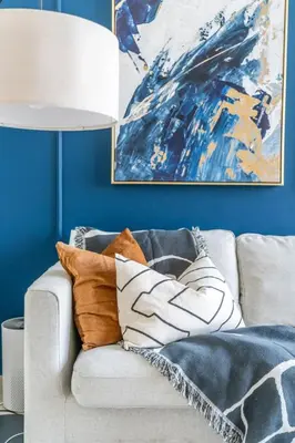 a living room with a couch with pillows and a painting at Guest Favourite! Beautiful 1 bedroom apartment in Dubai