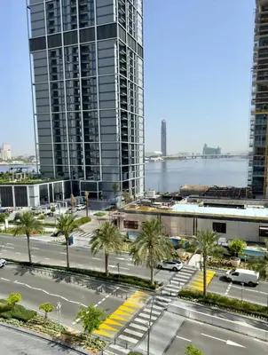 a city street with palm trees and tall buildings at Guest Favourite! Beautiful 1 bedroom apartment in Dubai