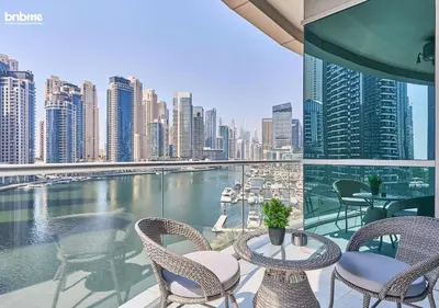a balcony with chairs and tables and a view of a city at bnbmehomes - DAMAC Waves Tower in Dubai