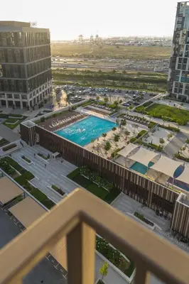 a view of a pool from the balcony of a building at Oraya - Brand New 2BR Apt in Socio Tower at Dubai Hills in Dubai