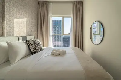 a bedroom with a large white bed with a window at Oraya - Brand New 2BR Apt in Socio Tower at Dubai Hills in Dubai