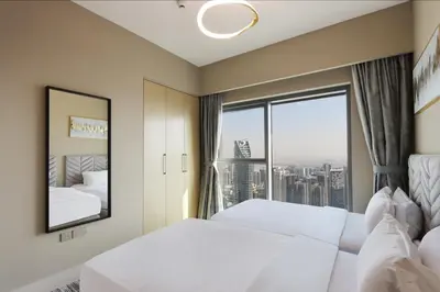 a hotel room with two beds and a large window at Livbnb - 3BR Deluxe suite w/ Burj Khalifa & Fountain Views in Dubai