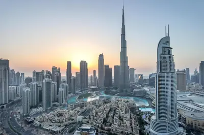 an aerial view of the dubai city skyline at sunset at Livbnb - 3BR Deluxe suite w/ Burj Khalifa & Fountain Views in Dubai