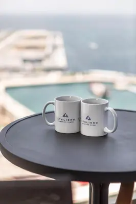 two white coffee mugs sitting on top of a table at Chic Apartments in Marina Vista Emaar Beachfront in Dubai