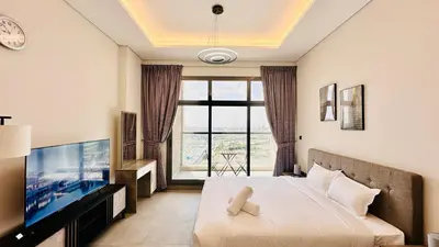 a bedroom with a bed and a large window at Oval Tower Furnished Studio Business Bay in Dubai