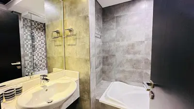 a bathroom with a sink and a shower and a sink at Oval Tower Furnished Studio Business Bay in Dubai