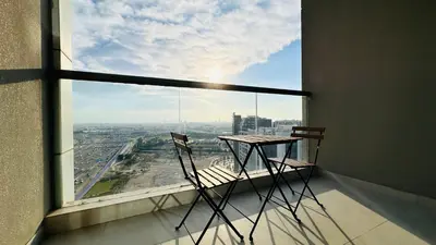 a table and two chairs in a room with a large window at Oval Tower Furnished Studio Business Bay in Dubai