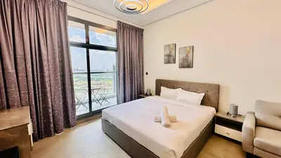 a bedroom with a bed and a large window at Oval Tower Furnished Studio Business Bay in Dubai