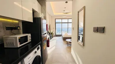 a kitchen with a microwave on a counter with the ocean at Oval Tower Furnished Studio Business Bay in Dubai