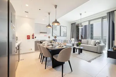 a dining room and living room with a table and chairs at Forte Tower - Downtown Dream, Ocean View, Opposite Dubai Mall in Dubai