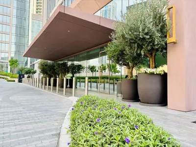 a building with trees and flowers in front of it at Forte Tower - Downtown Dream, Ocean View, Opposite Dubai Mall in Dubai