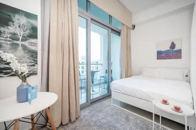 a bedroom with a bed and a large window at StoneTree - Chic Studio - Near Beach in Dubai