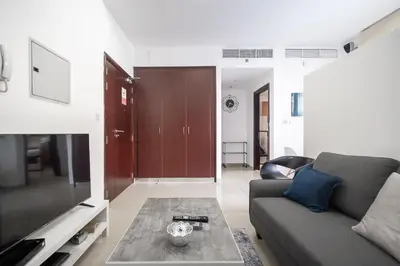 a living room with a couch and a table at StoneTree - Chic Studio - Near Beach in Dubai
