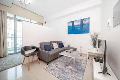 a living room with a couch and a table at StoneTree - Chic Studio - Near Beach in Dubai