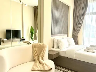 a white hotel room with a bed and a tv at ASHRI HH, STANDARD STUDIO IN STUDIO CITY in Dubai