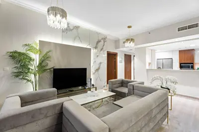 a living room with a couch and a tv at Luxe 2BR Burj Vista Retreat, Steps from Dubai Mall & Burj Khalifa in Dubai