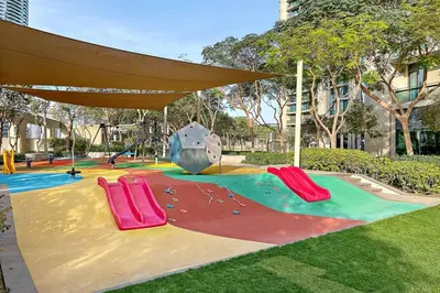 a park with a playground with slides and a slide at Luxe 2BR Burj Vista Retreat, Steps from Dubai Mall & Burj Khalifa in Dubai