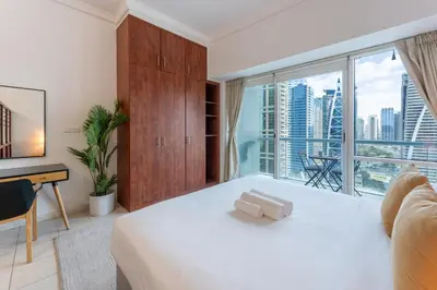 a bedroom with a white bed and a large window at Lake Terrace - Vibrant Studio in Dubai