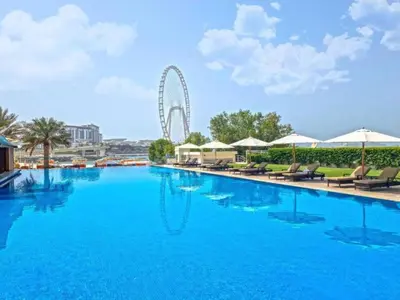 a large swimming pool with a ferris wheel in the background at 1BR Apartment, Full Sea and JBR View in Dubai