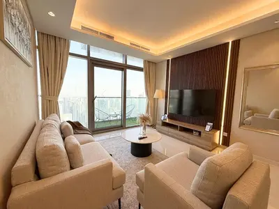 a living room with a couch and a television at Spectacular views on high floor with Infinity Pool in Dubai