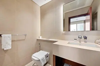 a bathroom with a toilet and a sink and a mirror at Luxury 2BR with Marina Views Near Dining Shopping Attractions & Beaches in Dubai