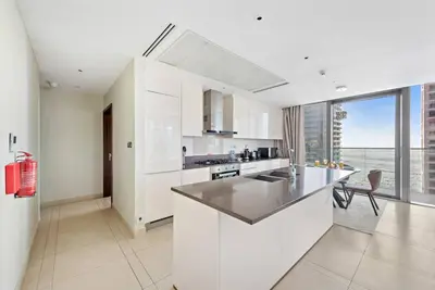 a kitchen with white cabinets and a large window at Luxury 2BR with Marina Views Near Dining Shopping Attractions & Beaches in Dubai