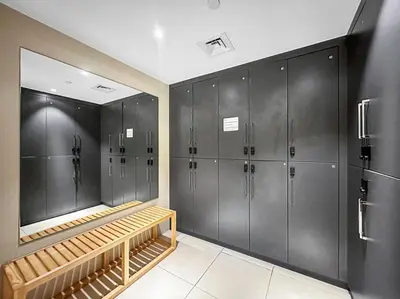 a locker room with gray lockers and a mirror at Dubai Marina 3BR Apartment, Steps to Marina Walk, Marina Beach & JBR in Dubai