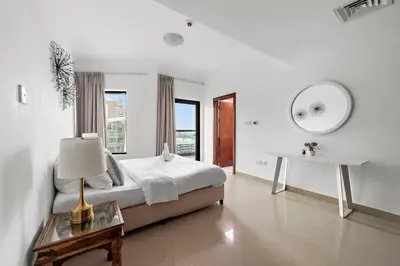 a bedroom with a bed and a table and a mirror at Dubai Marina 3BR Apartment, Steps to Marina Walk, Marina Beach & JBR in Dubai