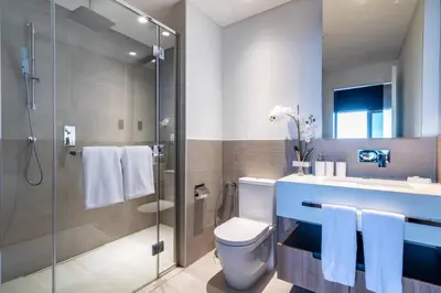 a bathroom with a toilet and a glass shower at Modern Studio Downtown DT1, Walk to Dubai Mall, Burj View & Metro in Dubai