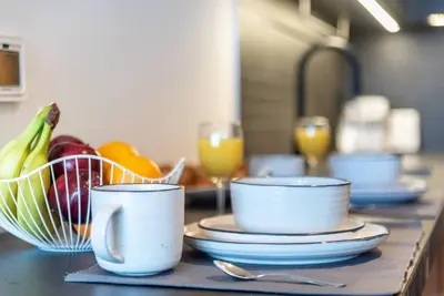 a counter with cups and plates and a bowl of fruit at Modern Studio Downtown DT1, Walk to Dubai Mall, Burj View & Metro in Dubai