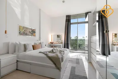 a white bedroom with a bed and a window at Keysplease 1 BR Polo Residence, Meydan in Dubai