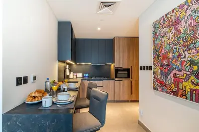 a kitchen with a large painting on the wall at FIRST CLASS Studio Stylish Urban Escape in Dubai