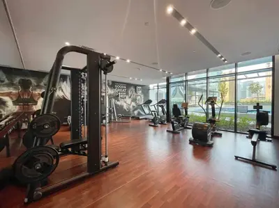 a gym with several treadmills and machines in a room at FIRST CLASS Studio Stylish Urban Escape in Dubai