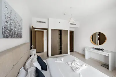 a living room with a couch and a mirror at FIRST CLASS 1BR Premium & Spacious City Escape in Dubai