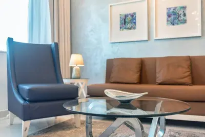 a living room with a couch and a glass table at FIRST CLASS 2BR Modern Downtown Retreat in Dubai