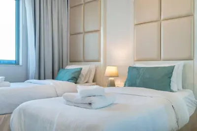 two beds in a hotel room with towels on them at FIRST CLASS 2BR Modern Downtown Retreat in Dubai