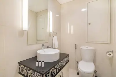 a bathroom with a sink and a toilet and a mirror at FIRST CLASS 2BR Modern Downtown Retreat in Dubai