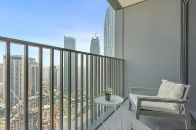 a balcony with a table and a chair and a city at Luxury Living with Panoramic View in Creek Harbour in Dubai