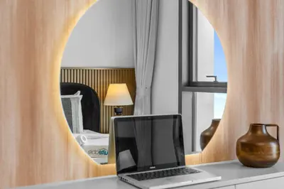 a laptop sitting on a counter in front of a mirror at Luxury Living with Panoramic View in Creek Harbour in Dubai