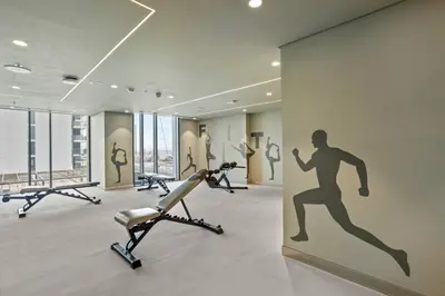 a gym with exercise equipment and a mural of a man at Luxury Living with Panoramic View in Creek Harbour in Dubai