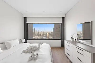 a white bedroom with a view of a city at FIRST CLASS 1BR Stunning Burj Khalifa Views in Dubai